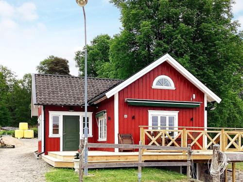 a red house with a porch and a deck at 4 person holiday home in ALLINGSÅS, SVERIGE in Hjälmared