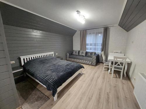 a bedroom with a bed and a table and a couch at Котедж у Ліску 2 in Vorokhta