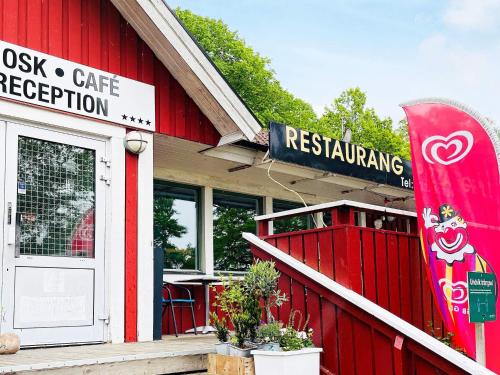 a red building with a snowboard outside of a restaurant at 4 person holiday home in ALLINGSÅS, SVERIGE in Hjälmared
