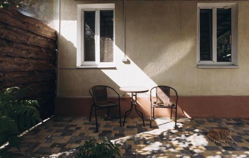 a patio with two chairs and a table in front of a building at Квартира в центре города in Sumy