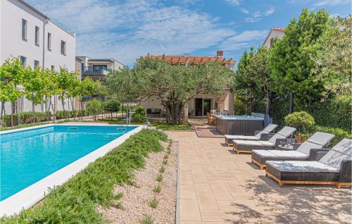 ein Swimmingpool mit Liegestühlen neben einem Gebäude in der Unterkunft Beach Front Home In Srima in Srima