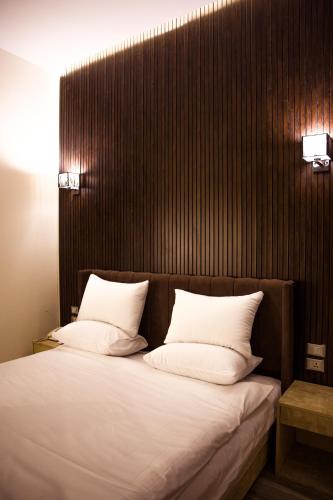 a bed with two white pillows on top of it at Tourist Palace Hotel in Cairo