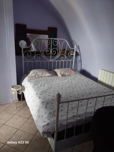 um quarto com uma cama e uma cabeceira em ferro forjado em Suite Viola@ em Legnano