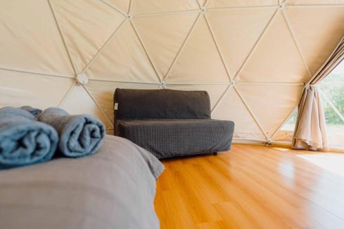 a room with a bed and a couch in a tent at Beavers Retreat Glamping in Tenby
