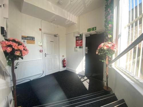 a hallway with stairs and flowers in a building at Hotel Royal in Blackburn