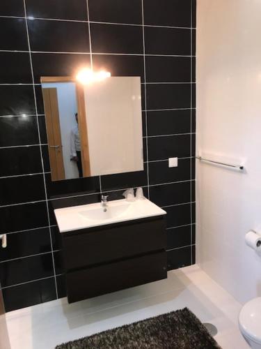 a bathroom with a sink and a mirror at Restaurante Residencial Pizzaria S. Estevão in Aguiar da Beira
