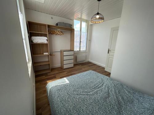 1 dormitorio con cama, armario y ventana en appartement, 