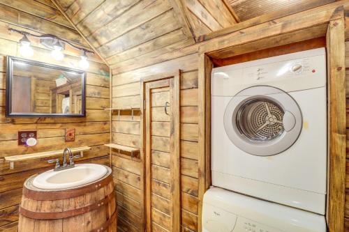 y baño con lavadora y lavamanos. en Rural Arkansas Vacation Rental with Wraparound Porch, en Heber Springs