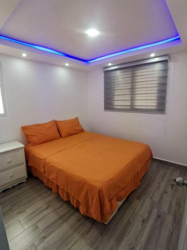 a bedroom with a bed with an orange blanket at Villa Rosa in Bejuquero