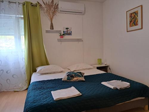 1 dormitorio con 1 cama con 2 toallas en Smještaj Latis en Vela Luka