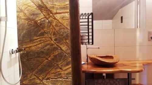 La salle de bains est pourvue d'un lavabo en bois et d'une douche. dans l'établissement Maison de caractère La Calade, à Rochecolombe