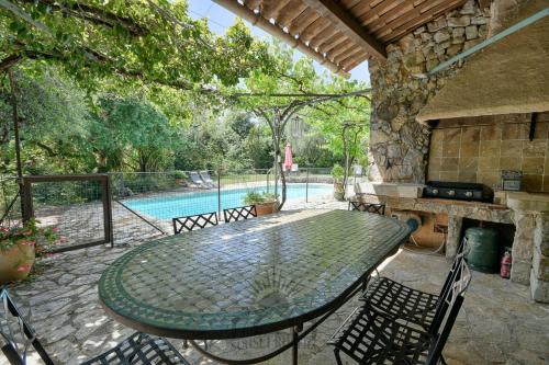 un patio avec une table et des chaises et une piscine dans l'établissement SERENITY Villa for 8 By Sunset, à Grasse
