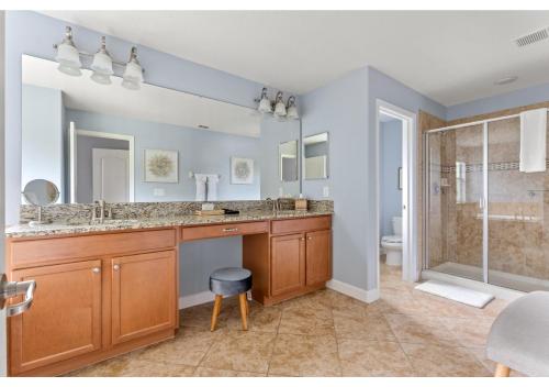 y baño con lavabo doble y ducha. en Lakefront 5BR Resort Pool Home Near Disney World, en Kissimmee