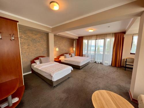 a hotel room with two beds and a balcony at Hotel Millennium in Pogradec