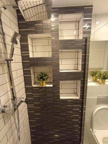 a bathroom with a tiled wall with potted plants at Apartament Brzeg in Brzeg