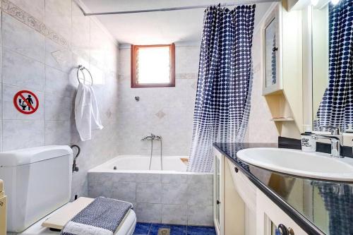 e bagno con vasca, servizi igienici e lavandino. di Eva’s Place Panoramic Sea View a Souda (Suda)