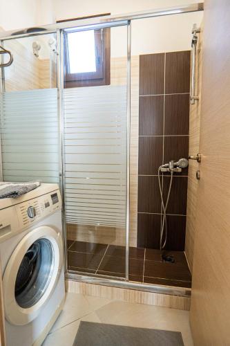 a washing machine in a bathroom with a shower at Sunset Villa in Hanioti