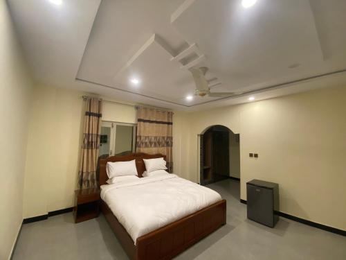 a bedroom with a bed and a ceiling fan at Desert One Hotel Skardu in Skardu