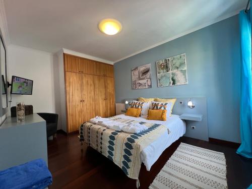 1 dormitorio con 1 cama con pared azul en Casa Do Pico by AnaLodges, en Machico