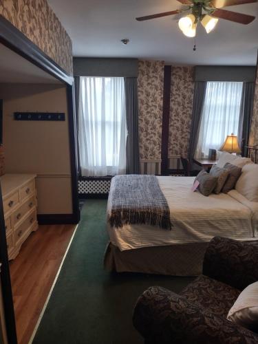 a hotel room with two beds and a ceiling fan at The King George Inn in Cobourg