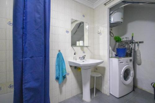 a bathroom with a sink and a washing machine at La Casa Del Abuelo in Vélez-Málaga