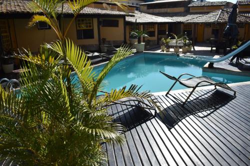 uma piscina com rede de descanso e uma palmeira em Nautillus Pousada em Arraial do Cabo