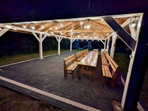 a picnic table under a pavilion at night at Domki Dolina Roztocza in Zwierzyniec