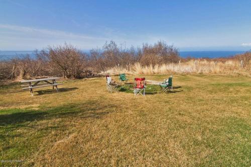 three chairs and a picnic table in a field at The Lookout - ALASKA SIZED VIEWS in Homer