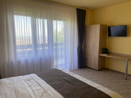 Habitación de hotel con cama y ventana en BELLESTAY en Brasov