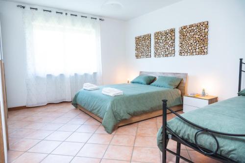 1 dormitorio con 2 camas y ventana en La Veranda Alpago, en Pieve dʼAlpago