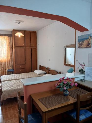 a bedroom with a bed and a table and a desk at P&G APARTMENTS in Naxos Chora