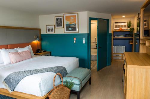 een slaapkamer met een bed en een blauwe muur bij Freebird Motor Lodge by Reverie Boutique Collection in West Yarmouth