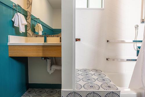 een badkamer met een wastafel en een spiegel bij Freebird Motor Lodge by Reverie Boutique Collection in West Yarmouth
