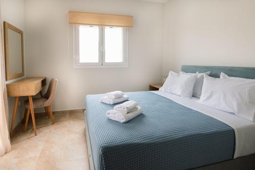 een slaapkamer met een bed met opvouwbare handdoeken bij Vasilopoulos Residences - Villa Emelia with shared pool in Argostoli