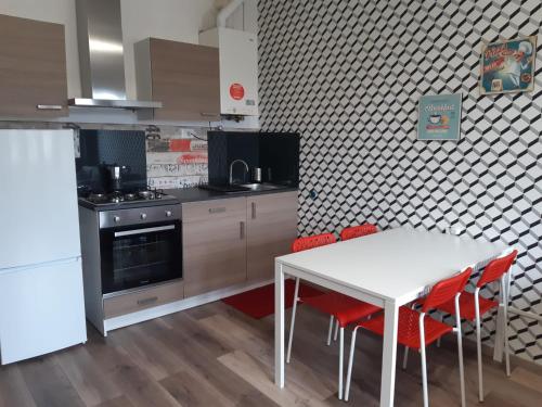 cocina con mesa blanca y sillas rojas en Appartamento ristrutturato - Castrocaro Terme, en Castrocaro Terme