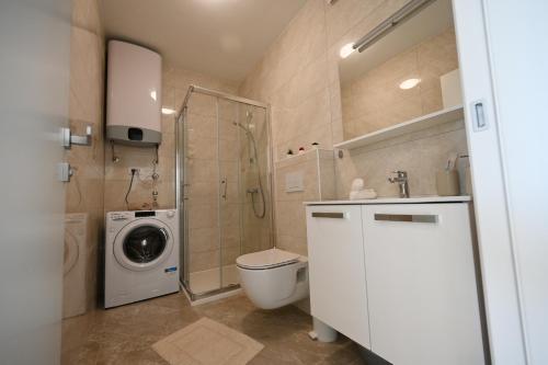 y baño con ducha, aseo y lavadora. en Apartman Lovre, en Zadar