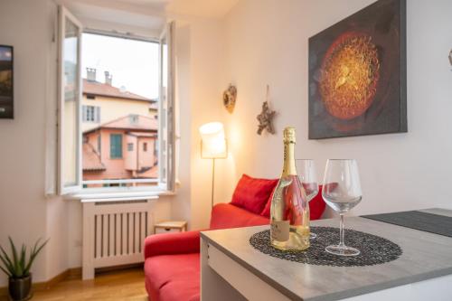 a living room with a bottle of champagne and a wine glass at PortaTorre Suite, a Charming apartment in the Heart of Como, Free Private Parking, Air Conditioning & More! in Como
