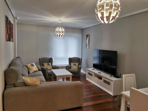 un soggiorno con divano e TV di Playa Home Noja a Noja