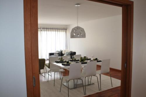a dining room with a table and white chairs at Charming Cascais Apt. in Cascais