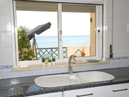a bathroom with a sink and a window with a view of the beach at Sunset Paradise in Armação de Pêra