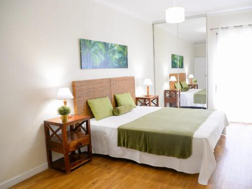 a bedroom with a large bed with green pillows at Sunset Paradise in Armação de Pêra