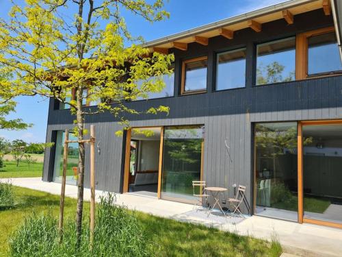 een huis met glazen deuren en een tafel ervoor bij Vintage studio am Chiemsee in Übersee