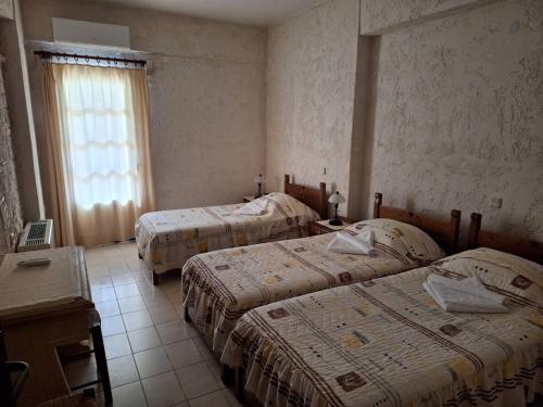 a room with three beds and a window at Mountain Vista Resort in Roústika