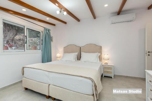 sypialnia z dużym łóżkiem i oknem w obiekcie Matsas House & Studio w mieście Paleokastritsa