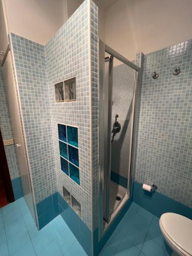 een badkamer met een douche met blauwe tegels bij La casetta di Chloè residence con Piscina in Santa Marinella