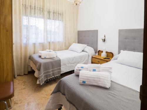 a bedroom with two beds and towels on the beds at MM DELTA HOLIDAYS in El Lligallo del Gànguil