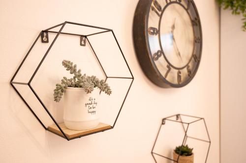 a shelf with a plant and a clock on a wall at Porta Torre suite - Como Lake city center - Free parking , air conditioning in Como