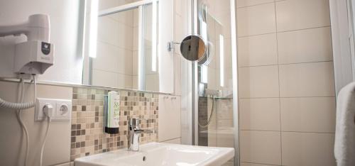 a bathroom with a sink and a mirror at Hotel-Restaurant Jagdhaus Heede in Hannoversch Münden