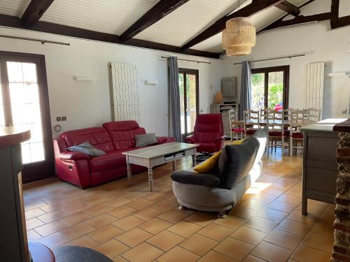 - un salon avec un canapé et des fauteuils rouges dans l'établissement La bergerie des Landes, à Lit-et-Mixe