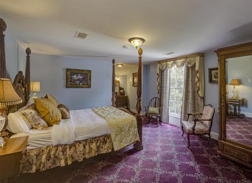 The Inn at Cedar Grove في فيكسبيرغ: غرفة نوم مع سرير كبير مع سجادة أرجوانية